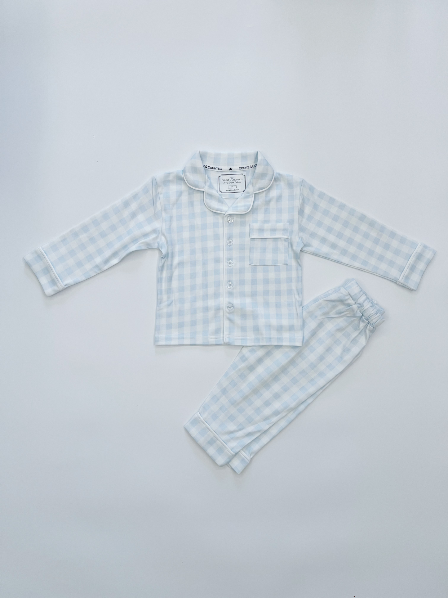 Children's light blue checkered shirt and pants set on a white background