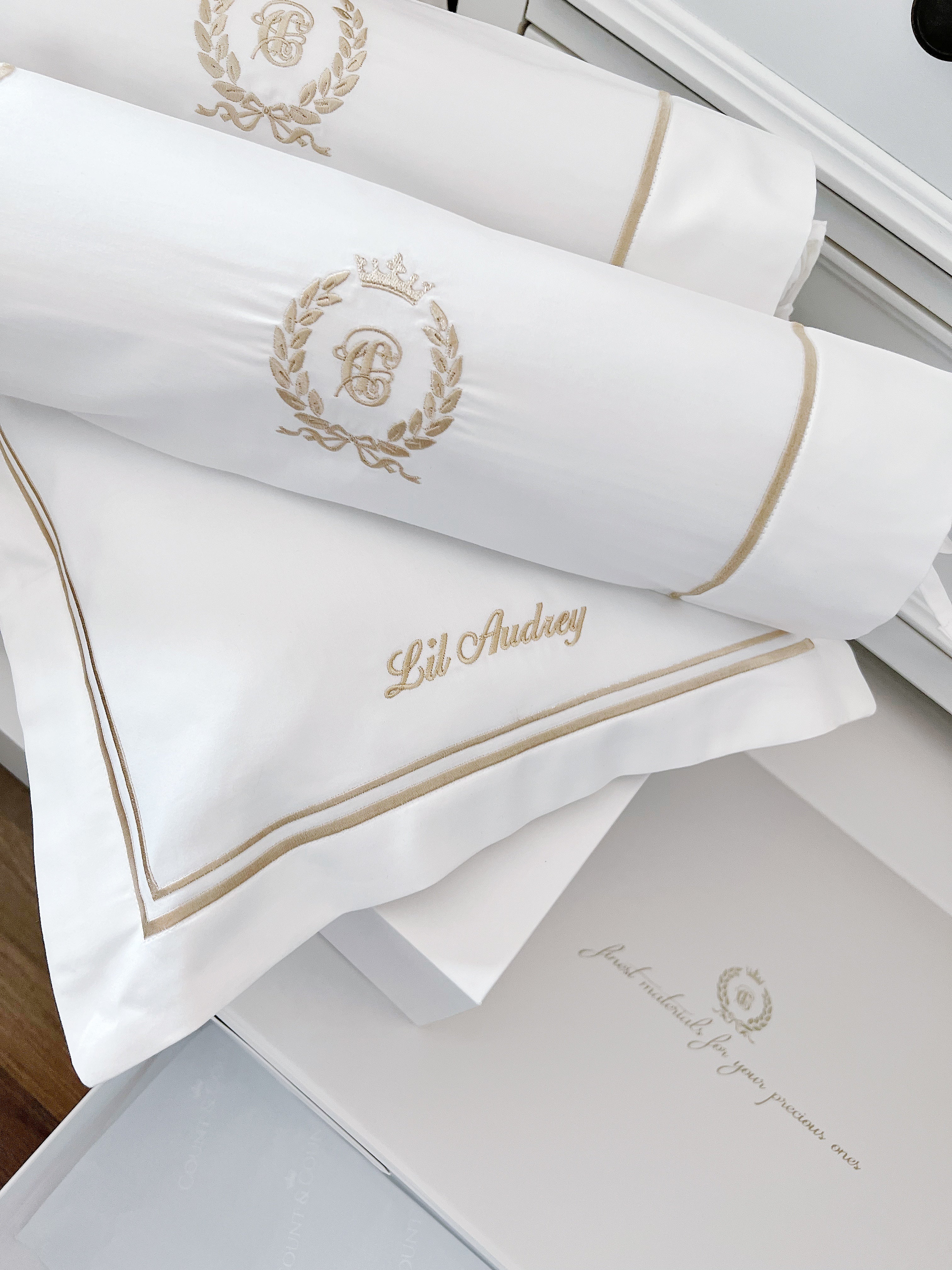 White pillows with gold embroidery on a bed
