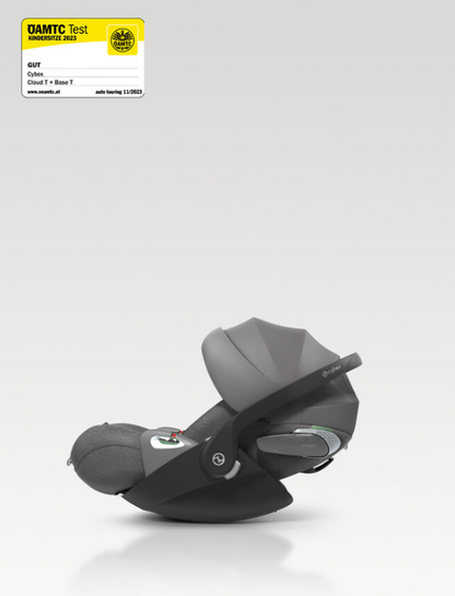 A side profile view of a grey and black Cybex baby car seat on a light grey gradient background, with a DAMTC Test Germany Pass certification sticker in the top left corner.